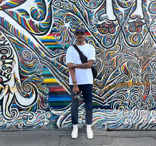 ahmed abdallah standing in front of a painted wall