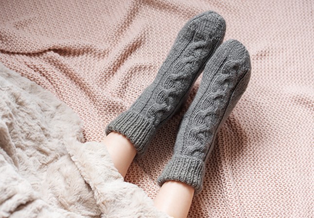 Legs of a young girl wearing knitted socks to bed.
