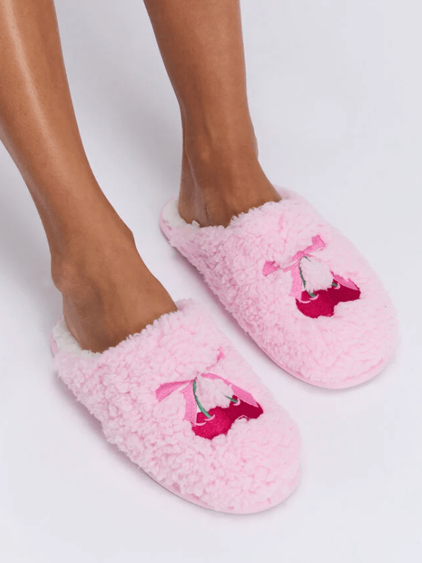 Female wears pink slippers with bow and cherry design
