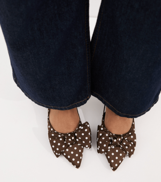 Female wears New Look Brown Polka Dot Satin Bow Embellished Slingback Flats