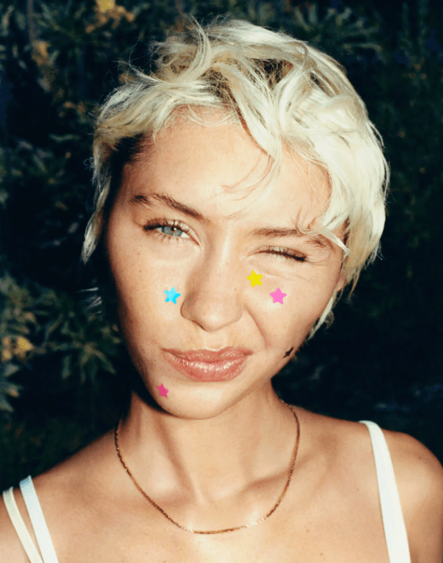 Female wears tiny spot stickers on her face