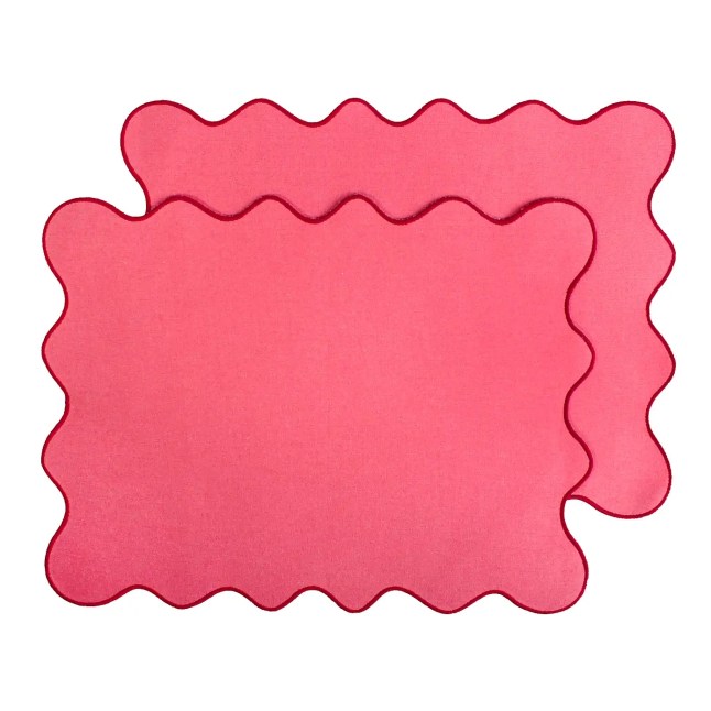 Two pink placemats with scalloped edge