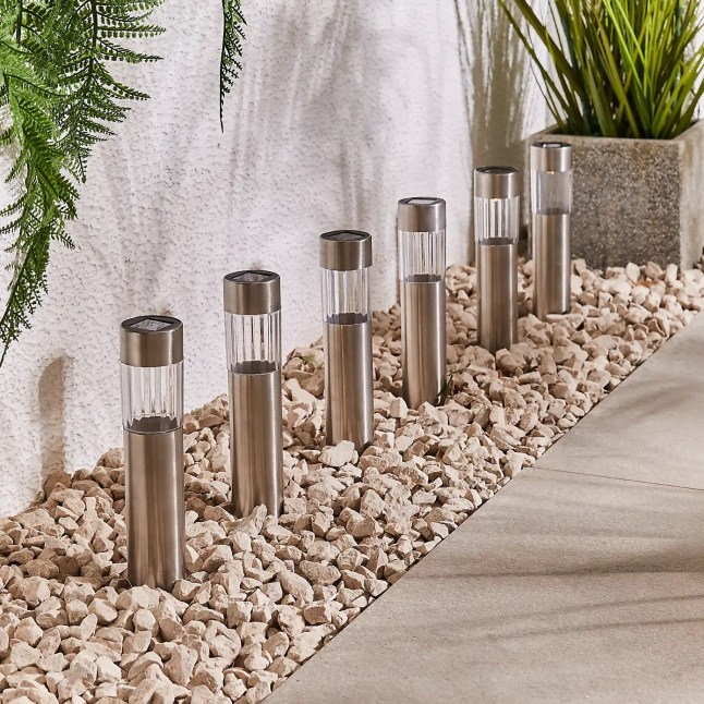 Silver lights in the ground, surrounded by stones