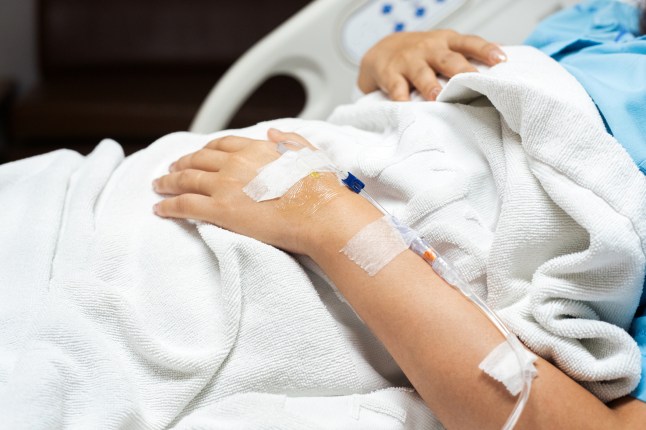 Close up of patient hand receiving IV drip in the hospital bed