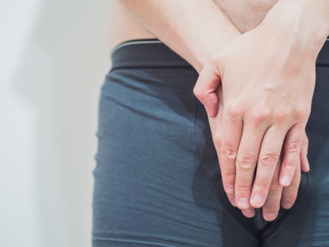 Embarrassed man in boxer shorts protecting his genitals. Sexual problems concept