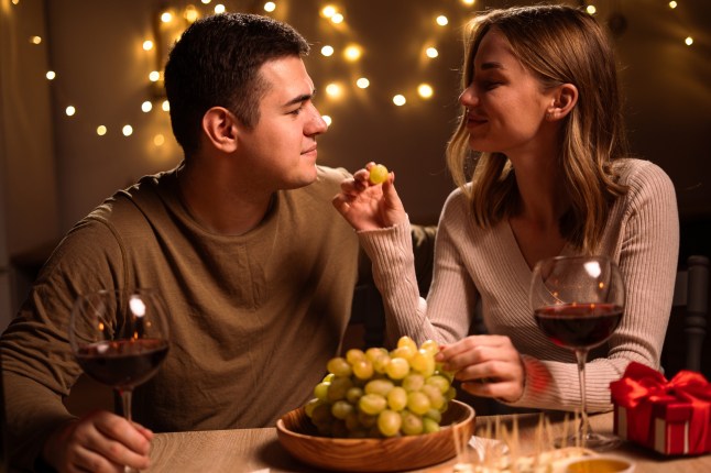 Happy couple having romantic dinner. Loving woman feeding her husband. celebrating Valentines Day. Date
