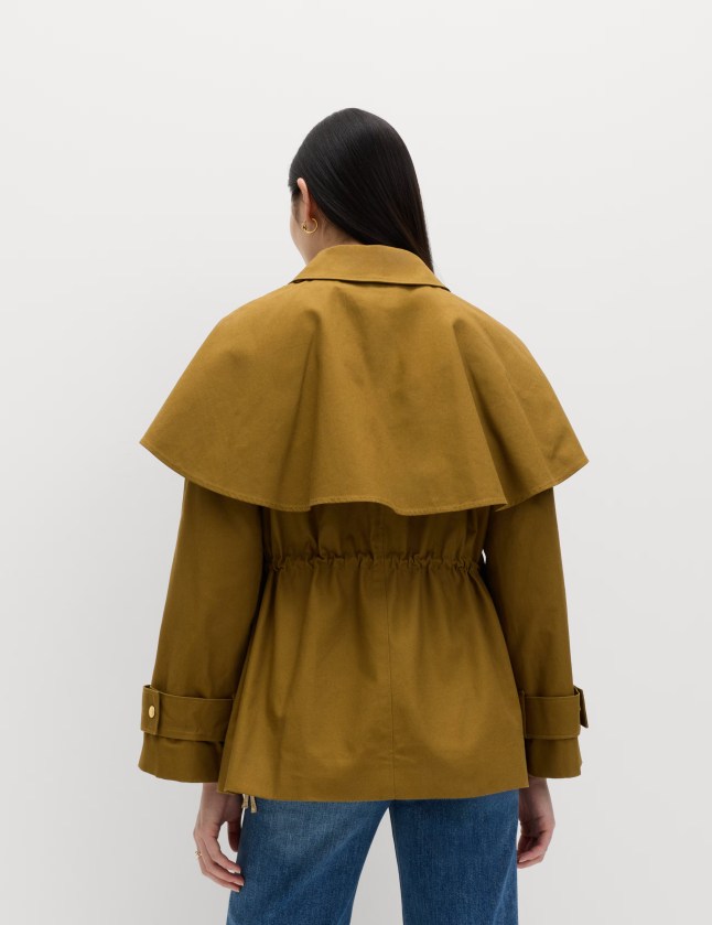 Back of female wearing dark green cropped jacket