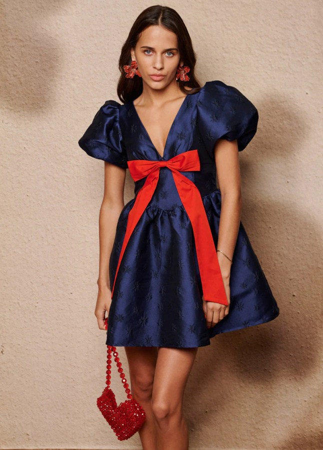 Female wears navy blue dress with oversized red bow
