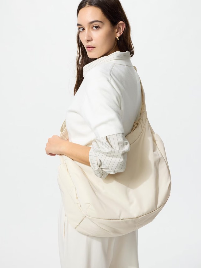 Female carries large white bag over her shoulder
