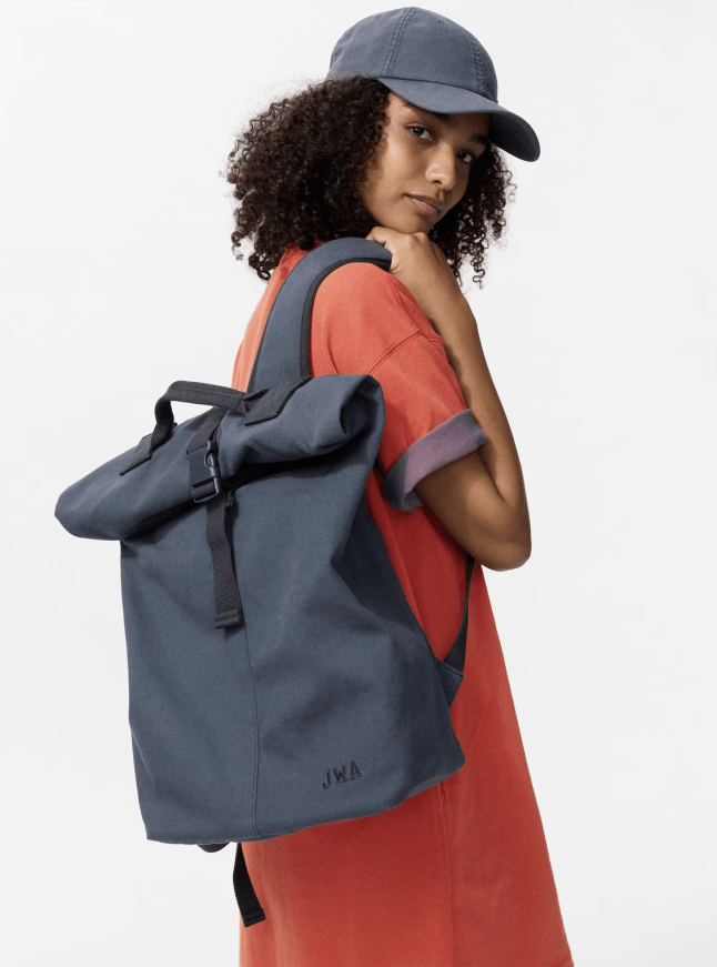 Female wears roll top bag